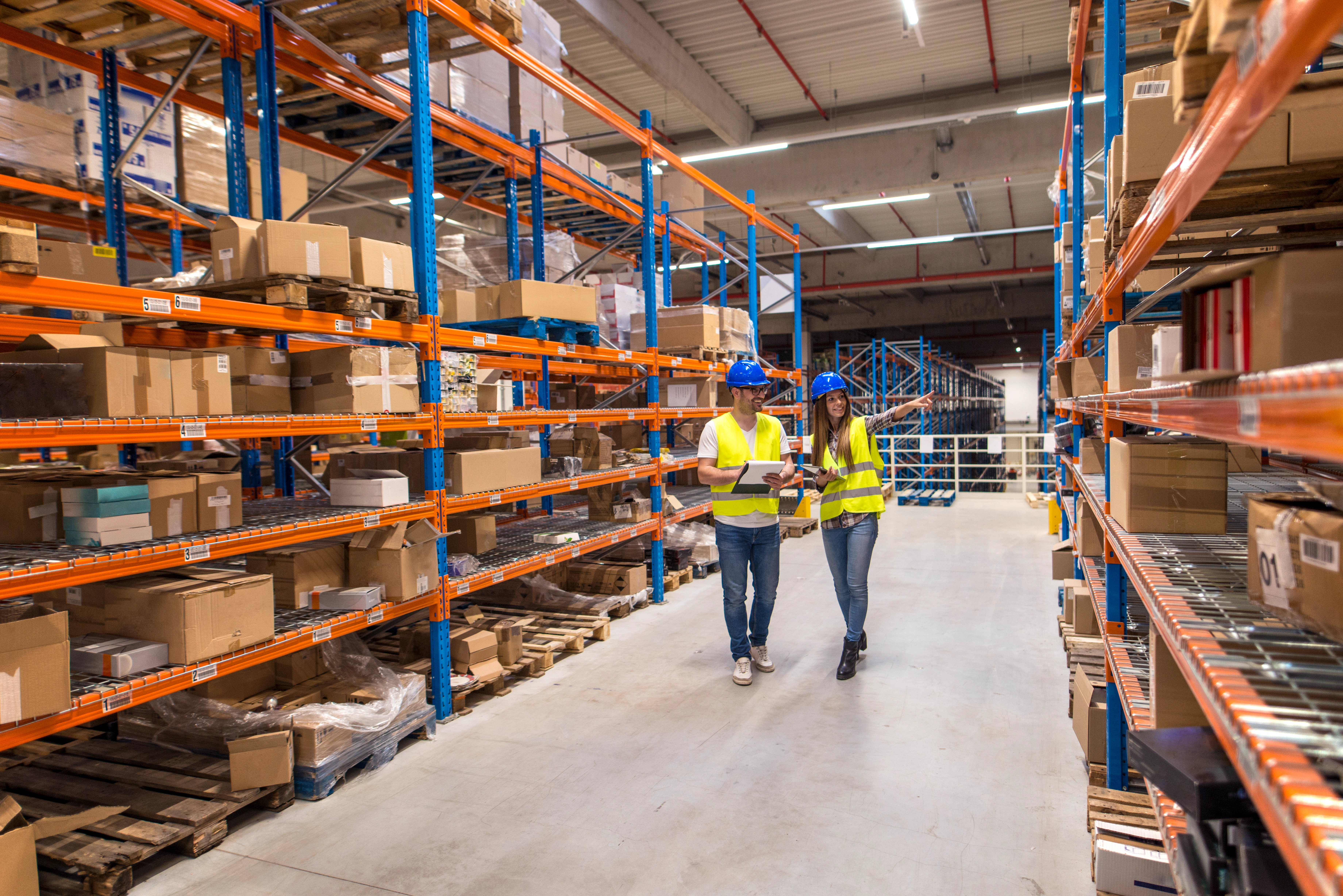 Supermarket staff walking a storage aisle during an operational audit