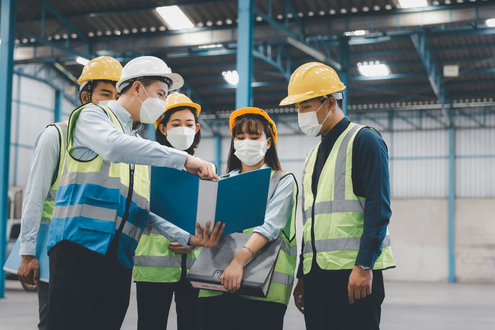 Factory team in masks holding a workplace safety meeting